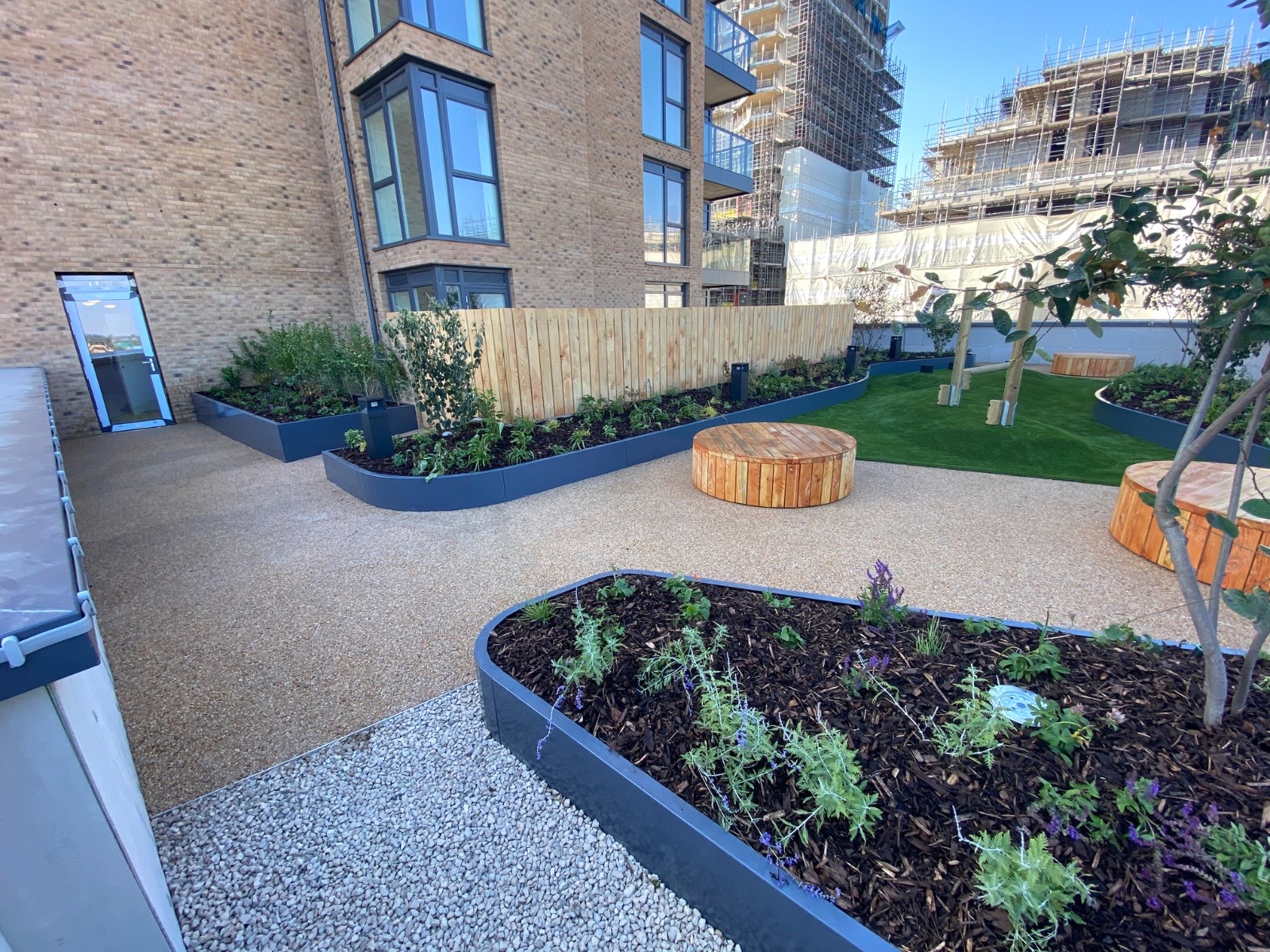 Contemporary courtyard with resin-bound surfacing and curved planters